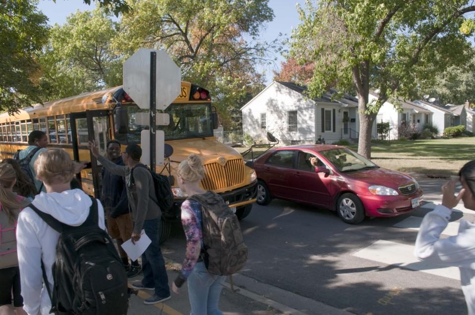 Crowding around: Students make their way to their buses at the end of the day Sept. 30. The new parking lot policy changes may make students navigate additional traffic to leave as well as increase the number of cars going down West 33rd Street. The added vehicles and people could make the street a more dangerous place for those leaving.