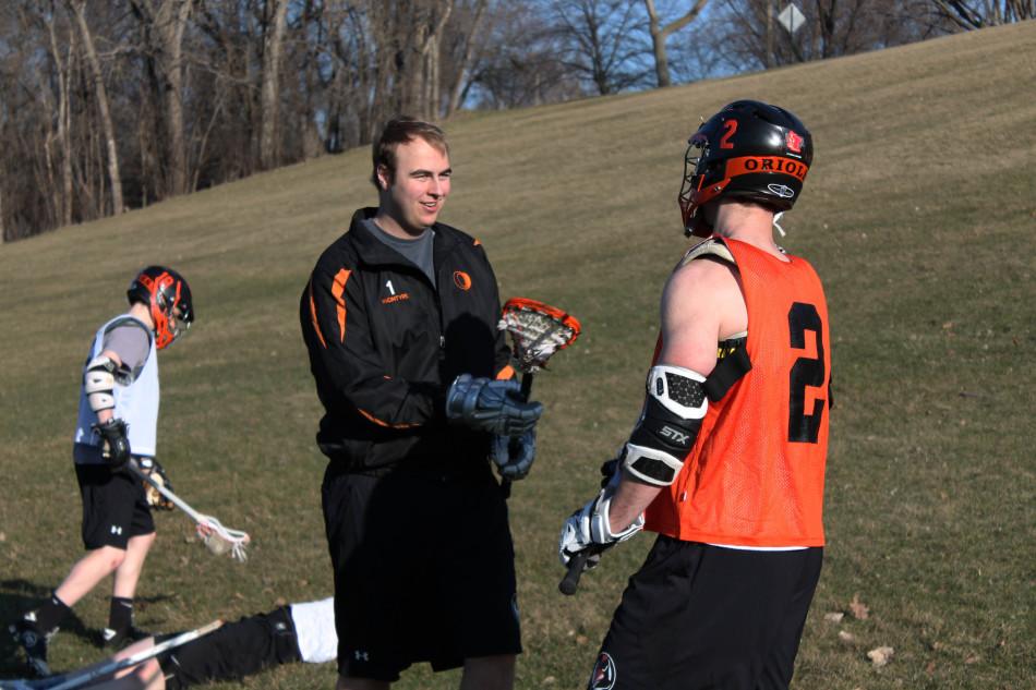 Junior Duncan McIntyre coaches former teammate, senior Joey Kramer, at practice April 21. The team occasionally practices at Ainsworth field.