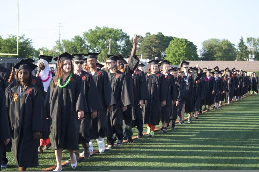 Lead by student council members, graduating seniors walk around the field before taking their seats.