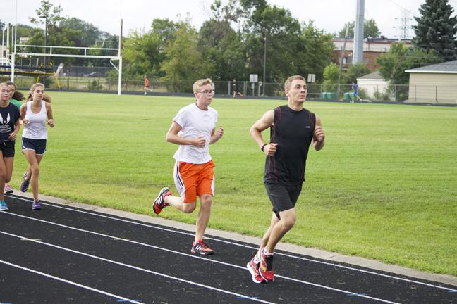 Sophomore Ethan Brown (left) and junior Nick Behnken run on the track during cross country practice on Aug 20.