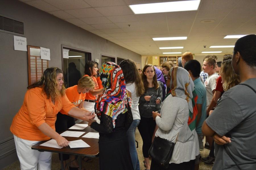 Staff members hand out name tags to incoming freshman at orientation on Aug 27.