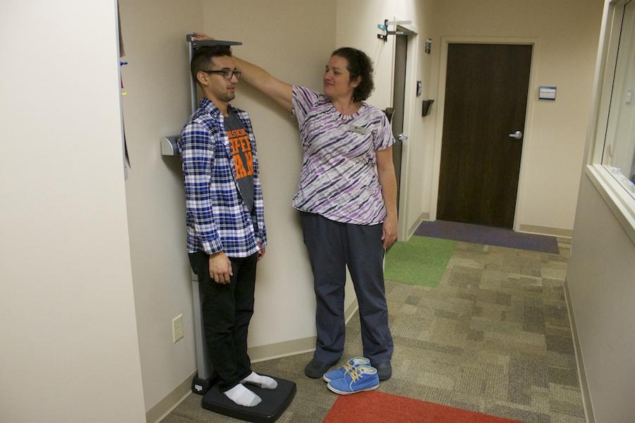 Senior Dave Herrera gets his height measured by one of the staffs nurses.