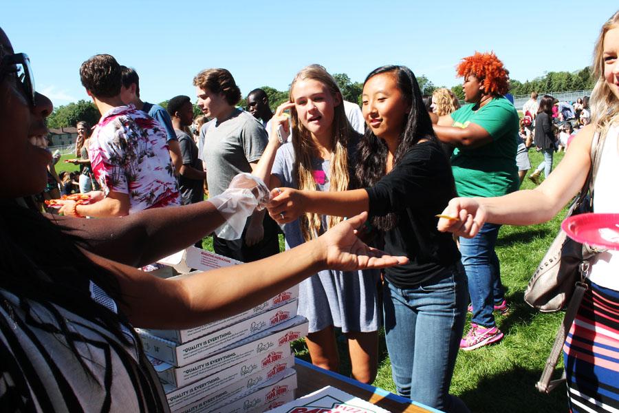 Day One members hand out pizza outside during the lunch hour.