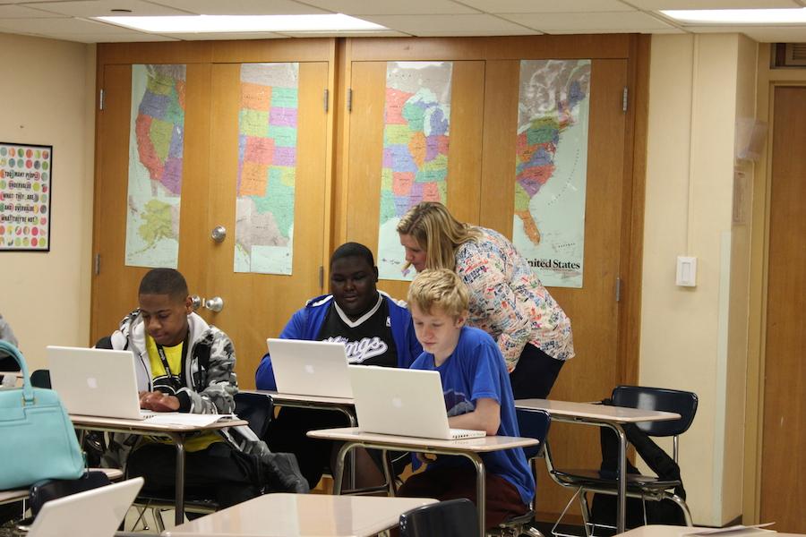 Civics teacher Sarah Lindenberg works with ninth grade civics students, using laptops in the classroom.