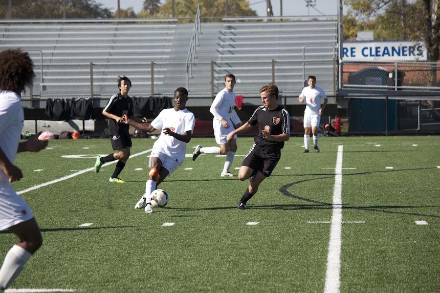 Senior Jonathan Tshiteya dribbles past a Minneapolis South player at the section game on Oct. 11.  The boys varsity soccer team won 2-1.