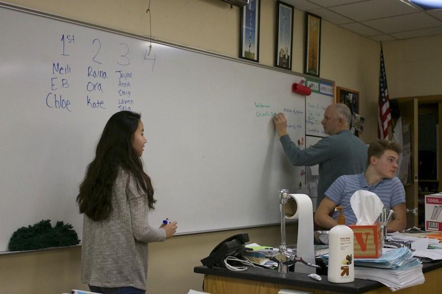 Sophomore Meili Liss organizes the names of those running the compost at a meeting before school on Jan. 29 in Mr. Wachutkas room.