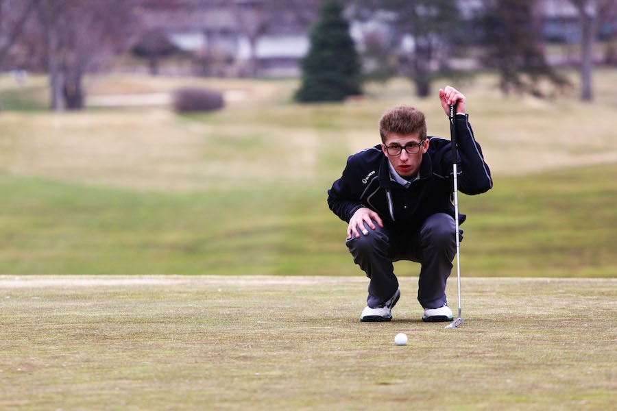 Line of play: Junior Mikey Segal reads the green before sinking his putt at practice April 7 at Minneapolis Golf Club.