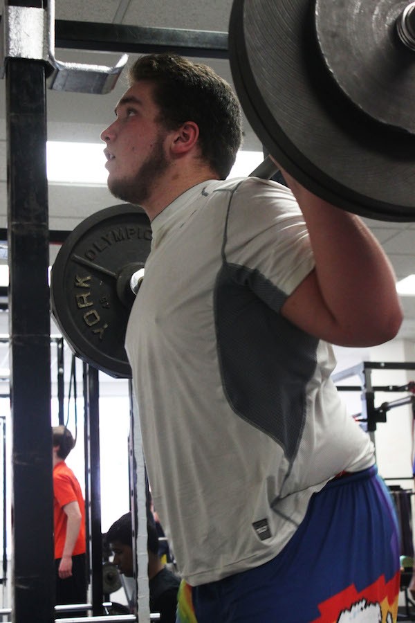 Senior DJ Wilkinson pushes through as he squats during his off season in preparation for college football March 26.