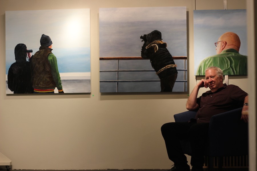 Contemporary artist Jerry Majkrzak sits among three of his paintings during a small preview of his work May 7. He is preparing for upcoming Art-A-Whirl festival May 15-17.