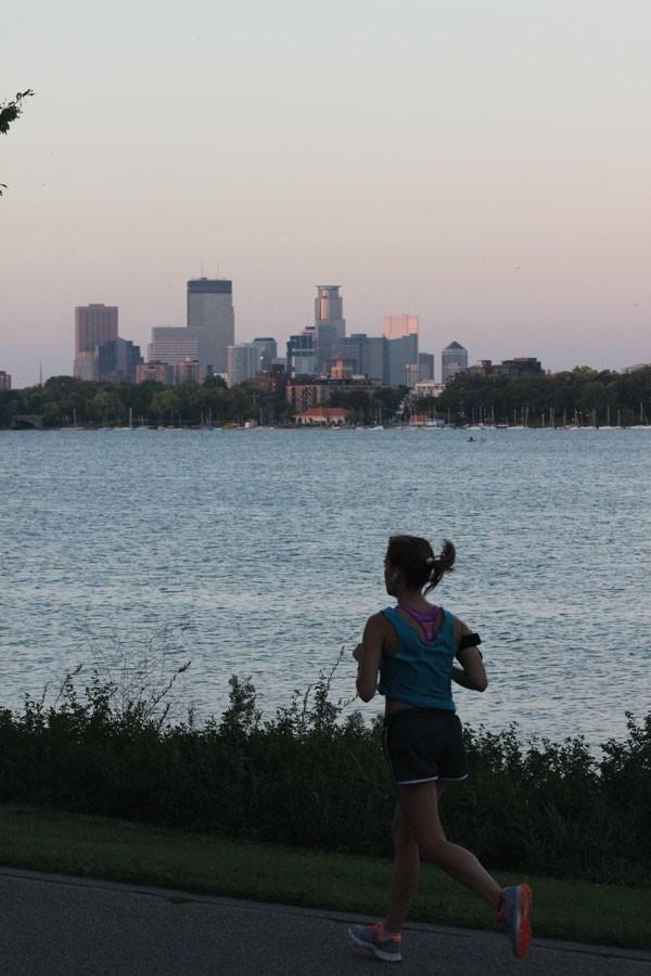 A jogger takes a lap around Lake Calhoun taking advantage of the view of the Minneapolis skyline.