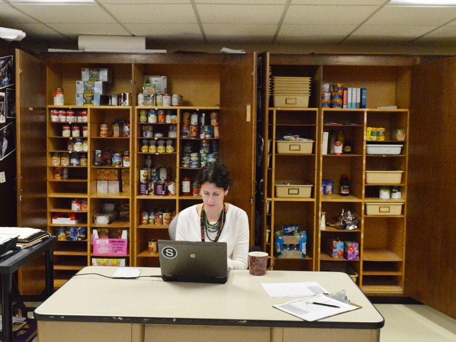 Bird Feeder adviser Sophia Ross sits at her desk in the food shelfs storage room, B226. The Bird Feeder has plans to partner with community organizations such as churches and sports teams to boost food donations.