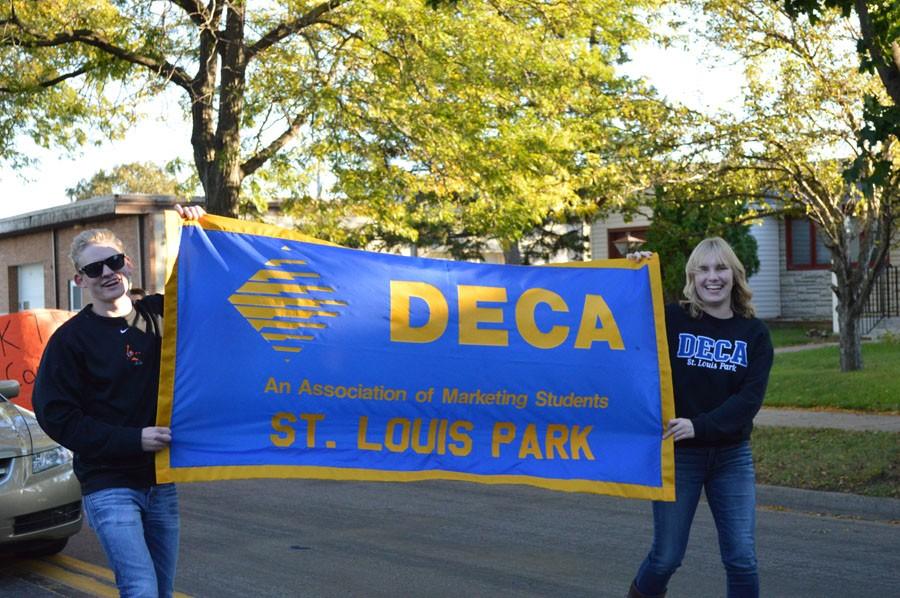 DECA officer and senior Jimmy Arms and junior Alyssa LeMay promote DECA in the homecoming parade. 