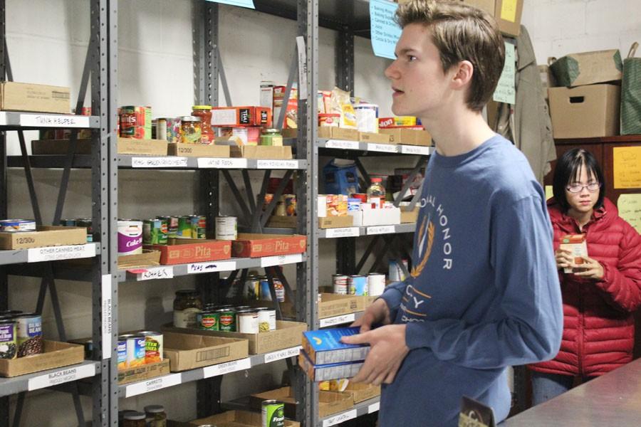 Junior Elliot Blackman, scans the shelves looking where to place a food item.