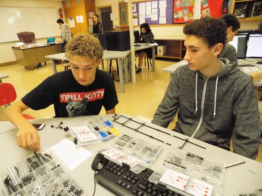 Sophomores John Schuebel and Charlie Schuebel work on their design during a robotics practice.