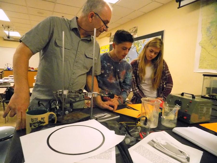 AP environmental science teacher Al Wachutka assists freshman Sophia Davenport and Wyatt Gann during a lab in class.