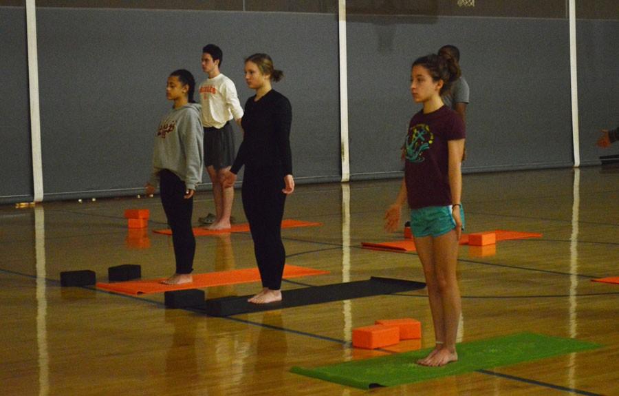 Students practice having good posture as they move through the yoga class.