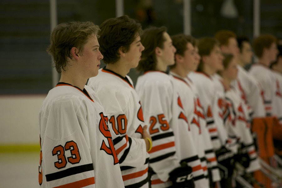 Varsity+hockey+players+stand+facing+the+flag+during+the+pre-game+national+anthem+before+playing+Mound+Westonka+Dec.+10.+Park+won+the+game+2-0.