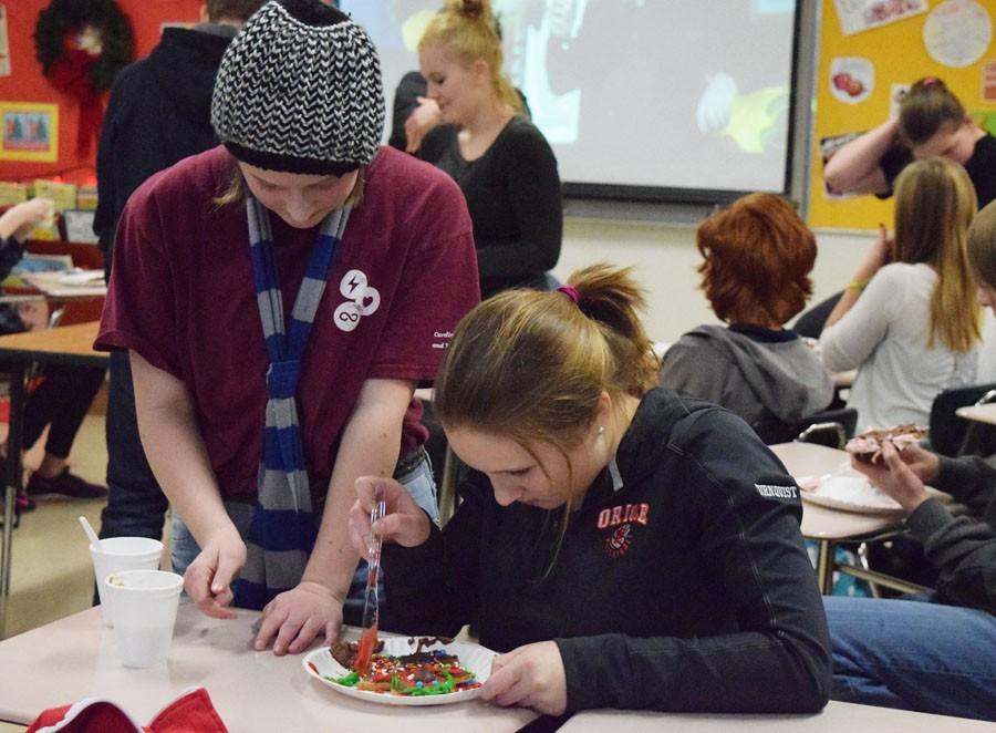 German club members decorate their ginger bread men with red and green frosting during the german club meeting Thursday Dec. 17. Meeting took place after school.