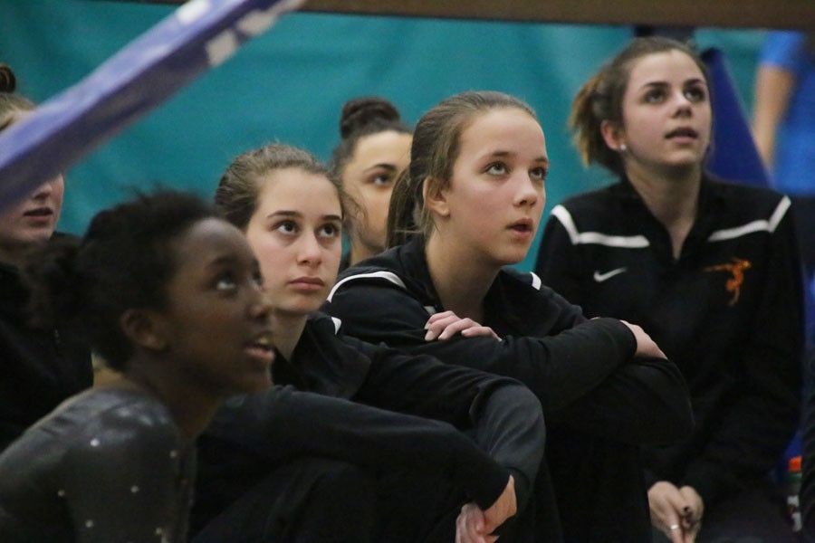 Middle school and High school gymnast watch as their teammates compete on the bars at the Jan. 26 meet with Hopkins