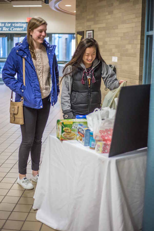 Drop off: Saint Louis Park alumni Kali Vinson and Addy Perkins donate food to the St. Louis Park Bird Feeder at a boys hockey game on Dec. 21.
