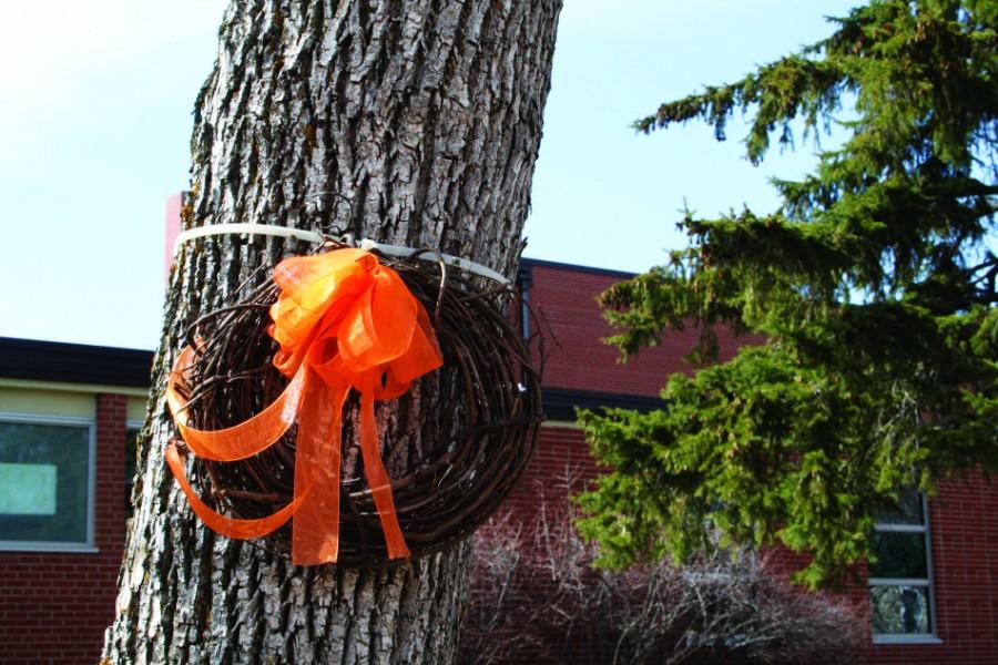 Wreaths decorated with orange ribbon outside of the high school honor Damian and Evan McManus in April 2014. With the new policy, memorials can be displayed for no longer than one week.