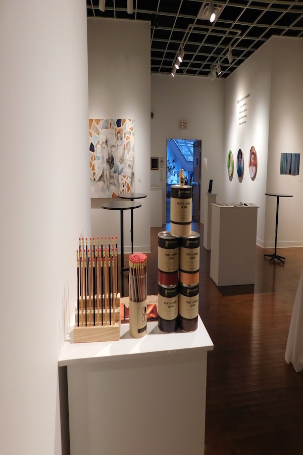 The exhibit features many different types of art. from paintings, to newspaper articles, to this display of pencils and paint cans.