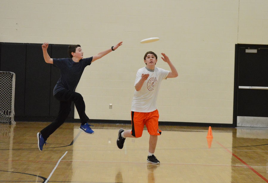 Freshmen Mathan Aknin and Ethan Khan reach for the frisbee during a scrimmage at practice.