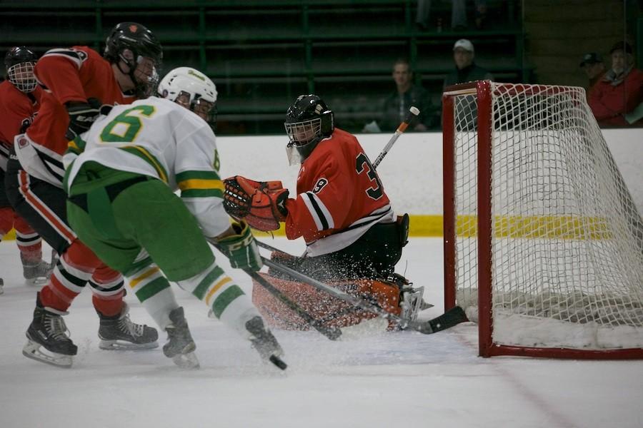 Senior goalie Connor Klaers looks at an Edina player handling the puck, waiting to block it from going in the goal during sections Feb. 18