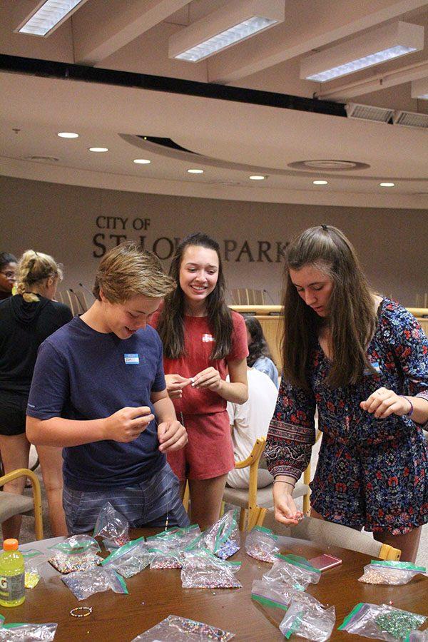 Freshmen Carly Neville, Shayla Miller and Ian Otos make bracelets during the first Student Council meeting Aug. 23. Members also talked about goals for the upcoming year.