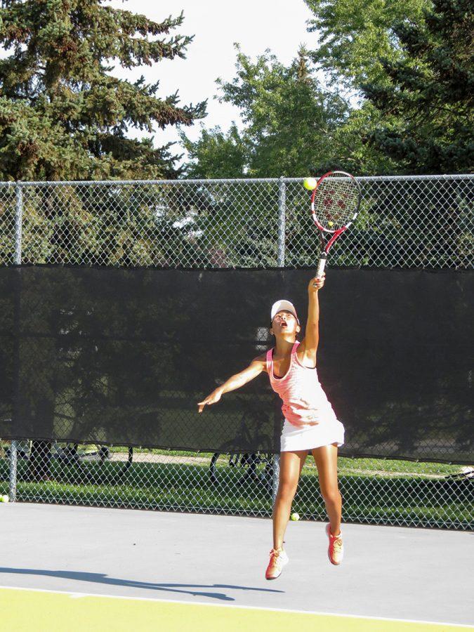 Sophomore Katie Hardie, a Tennis & Life Camp participant, strikes the ball on her serve during practice.