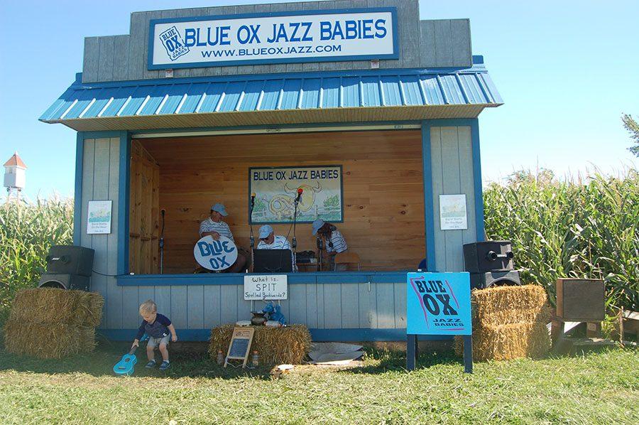 The Blue OX Jazz Babies set up to play for a crowd. They perform every hour and sell CDs at the front of the stage. On Saturdays from 12pm-4pm the band Pushing Chain performs and on 
Sunday from 12pm-4pm Michael Monroe plays. 