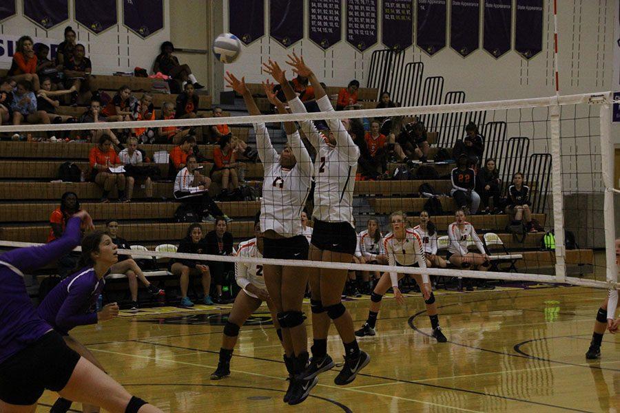 Senior Paige Steward and junior captain Ella Trotter block a hit from the Chaska Hawks. Steward recently committed to play volleyball at Luther College.