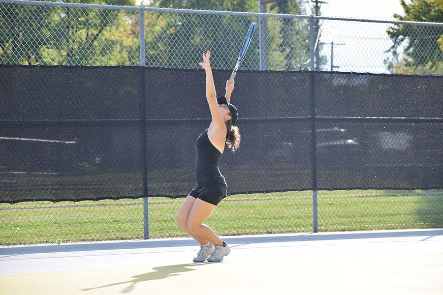 Junior Hanna Schechter serves the ball at two of her teammates while playing doubles during practice. 