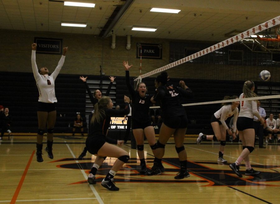 The varsity team celebrates after scoring a point during the fifth set.