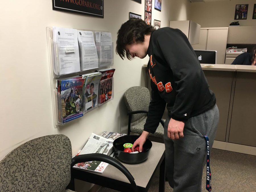 Junior Willy Basill grabs an apple from a fruit bowl provided by the athletic department. Bowls are located in the athletic office in the B1 hallway. 