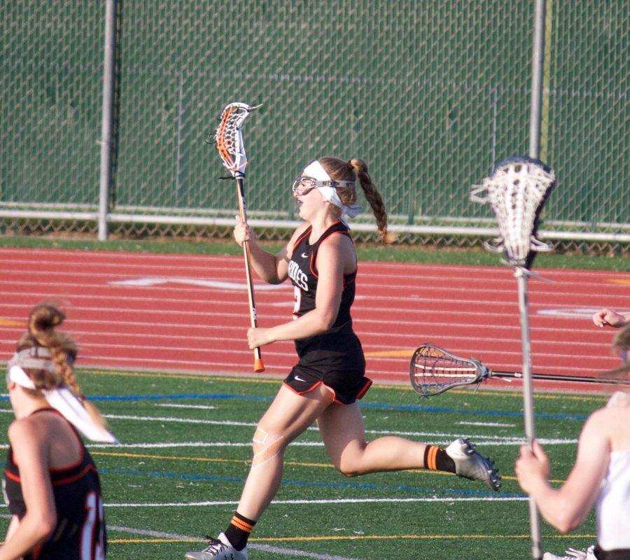 Junior Annie Van-Pilsum Johnson runs on the attack in the offensive zone during a lacrosse game. Van-Pilsum Johnson plays lacrosse and lifts weights in her time off nordic in order to stay in shape.
