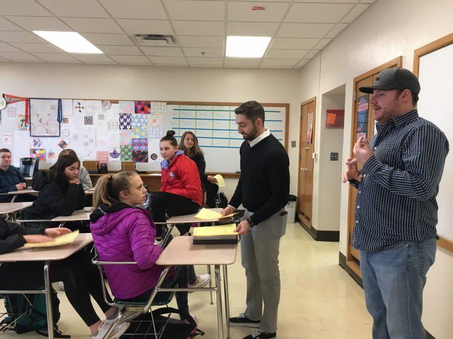 Girls golf head coach Zach Strouts passes out flyers during an informational meeting March 16. The season started March 20.
