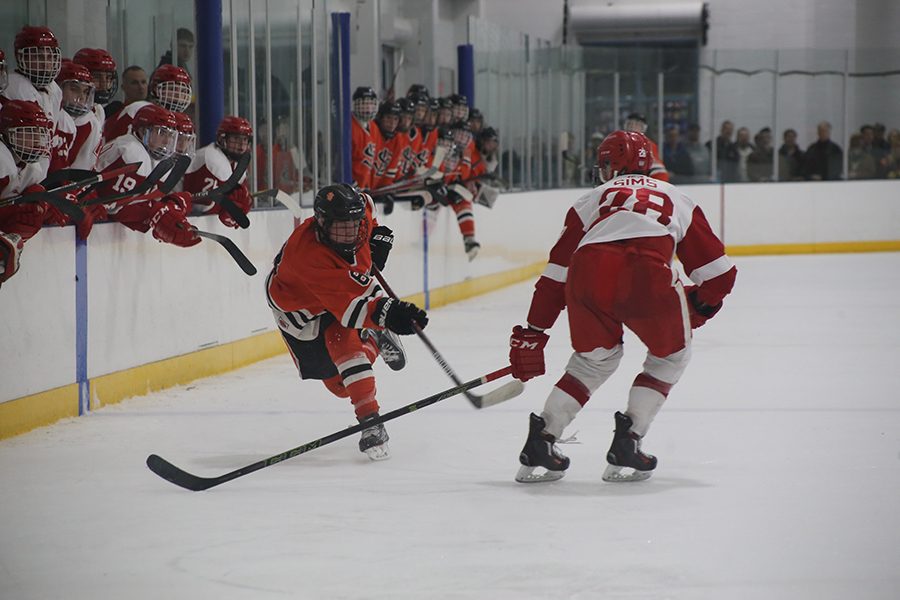 Senior captian Bauer Neudecker skates past Benilde senior Nick Sims Feb. 23. The Orioles won 5-3, advancing to Section 6AA semifinal against Edina Feb. 25, where they lost 7-1. Neudecker is no in Fairbanks, Alaska playing in the North American Hockey League for the Fairbanks Ice Dogs.