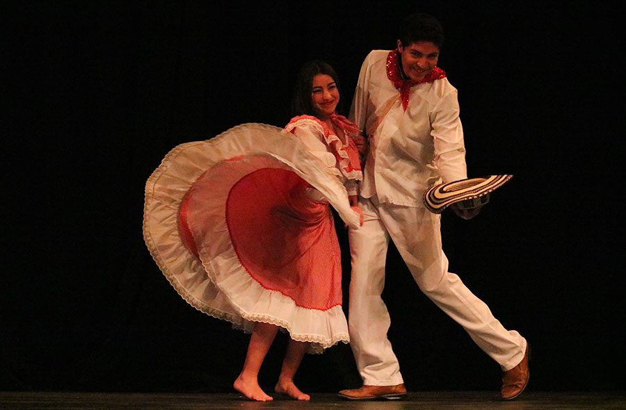 Senior Lukas Garcia Oppriecht and junior Maria Duarte Garcia pose during the fashion show as part of the Multicultural show. The two students are wearing outfits traditionally worn in Colombia.