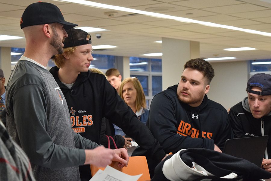 Head varsity coach Brian Kelly talks to seniors Connor Cornell and Julien Shadle and junior Brent Ryan after their pre-season meeting March 16. At the meeting Kelly discussed plans for the upcoming Arizona trip and the outline of the season.