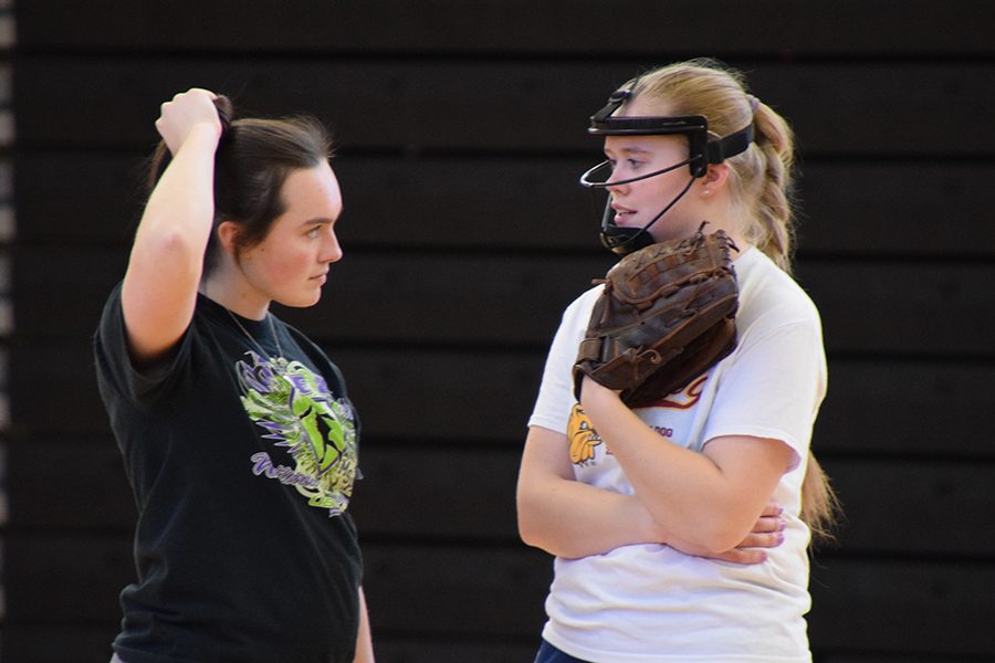 Softball senior captain Anya Lindell Paulson speaks with junior Annabelle Schutte at practice March 21. The team is practicing for its spring break trip to Kansas. 