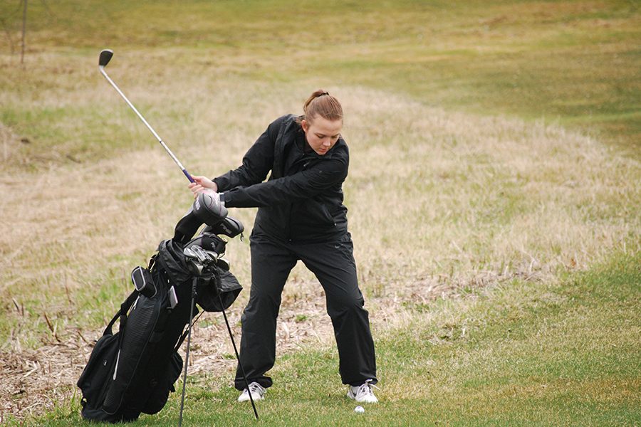 Junior Carly Livingston winds up for a chip shot at Theodore Wirth Park April 13.