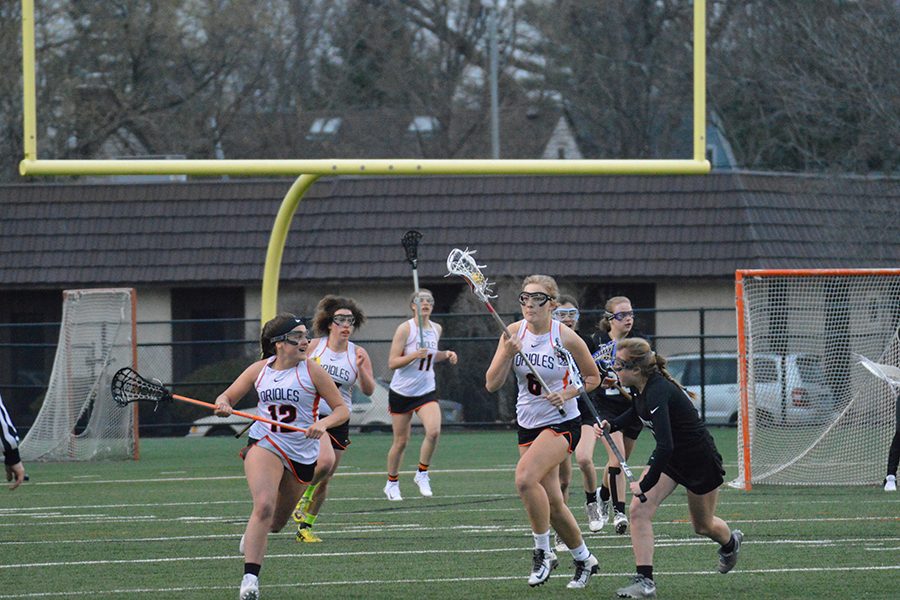 Senior Anna Roethler cradles the ball down the field as a Hopkins defender guards her. The next home again is April 20 against Benilde St. Margarets at 7:00pm.