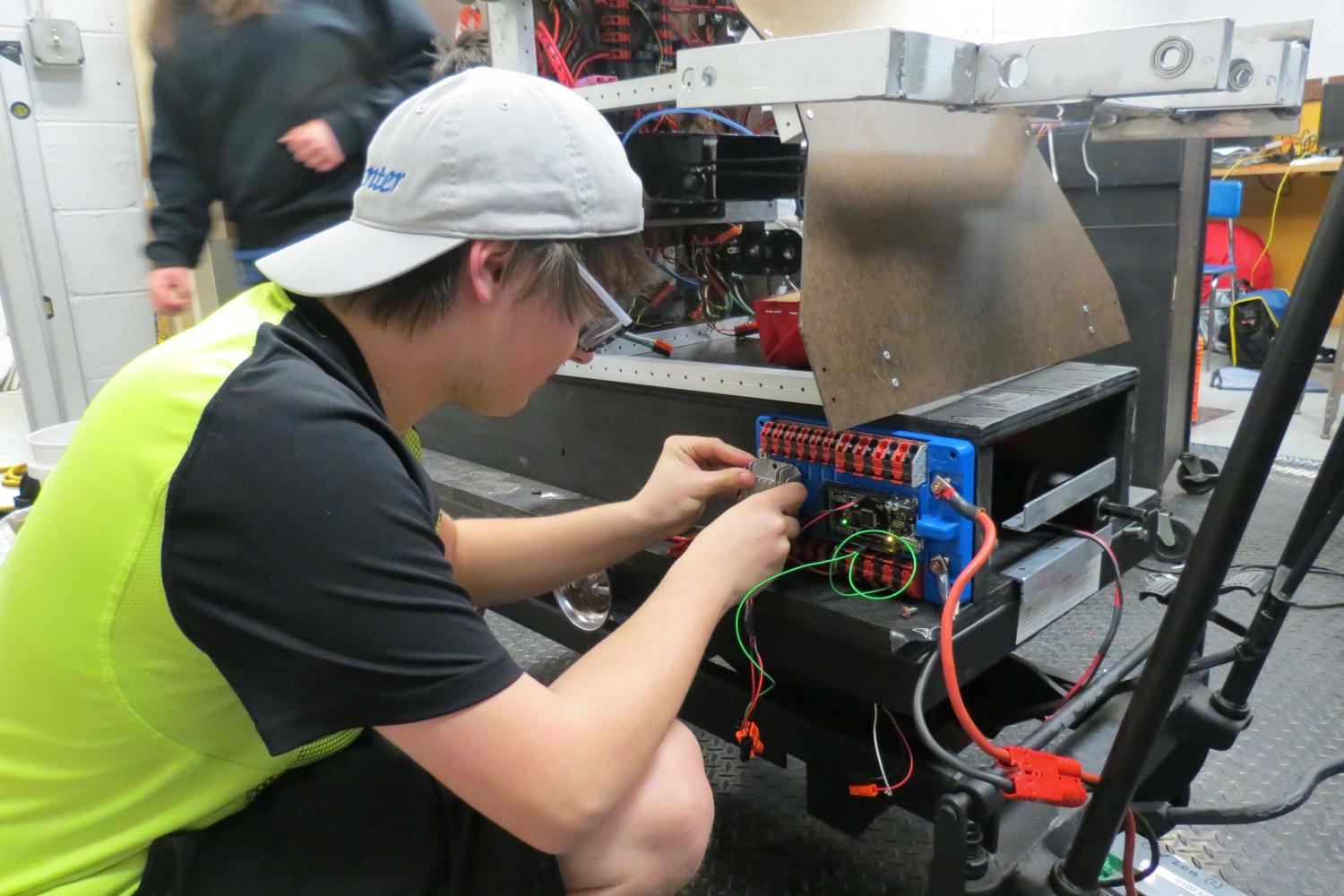 Junior robotics member, Lathan Wolf, wires a control panel on the teams robot in preparation to upcoming competition. 