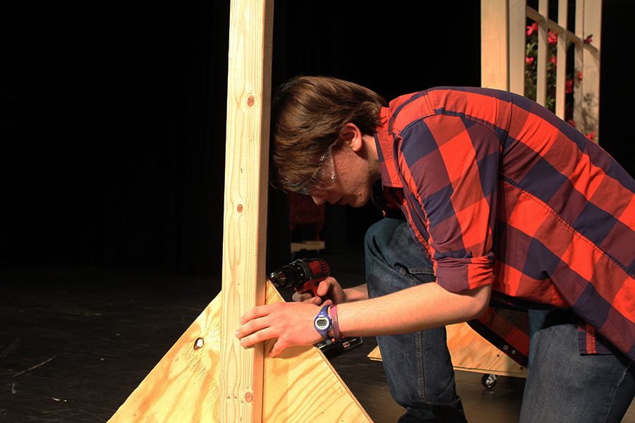 Cast and crew member, junior Thomas Bryant, works on building the set of the spring play, April 14.