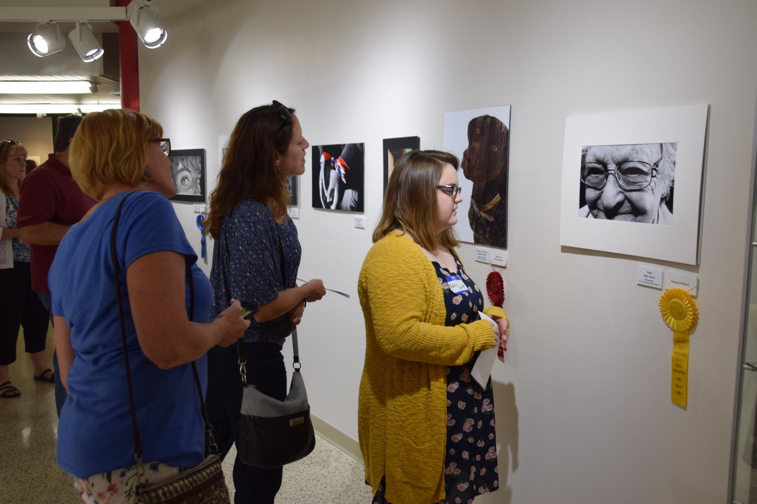 Senior Haley Larson surveys her photo Nana at the Metro West Conference Visual Art Exhibition. Larson won an award of merit for her photo. 