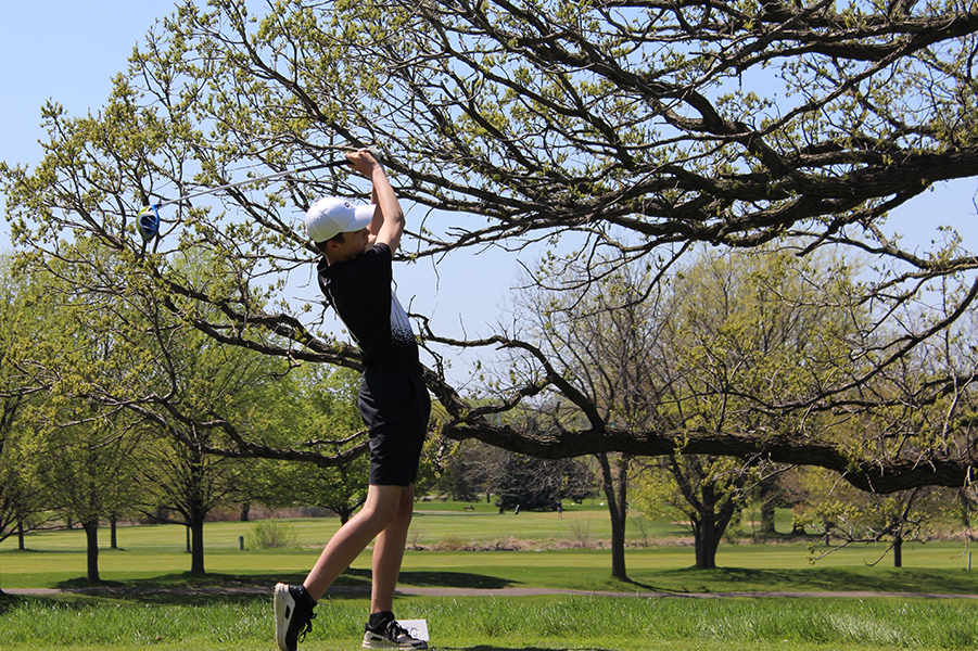 Freshman Charlie Harper holds his follow through after teeing off on the first hole. The teams next match takes place at 10 a.m. on May 31 at Sand Greek Golf Club for the section championships.