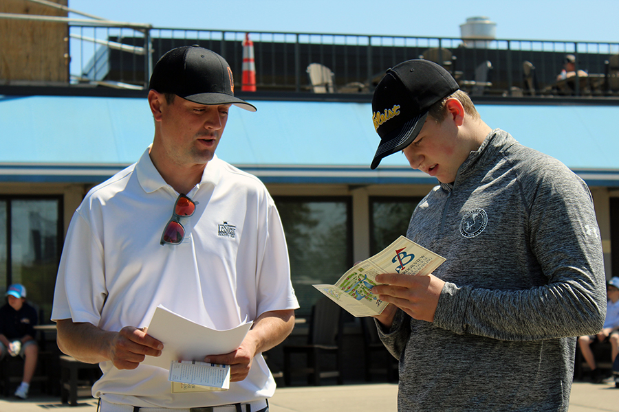 Boys golf captain Billy Nicholls reviews his score card and course map with head coach Mike Okey on May 5.