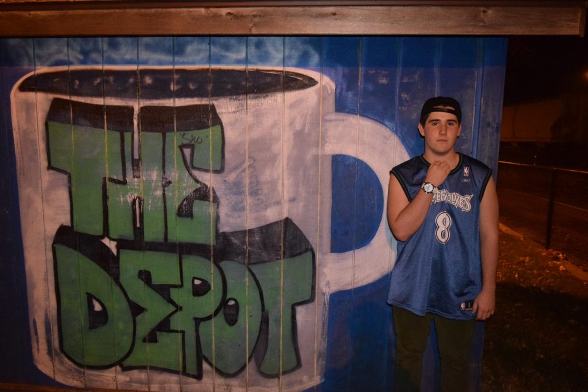 Junior Aidan Henry, who goes by the stage name ZAZ, poses by a mural at after a concert. ZAZ will perform at 8 p.m. Sept. 22 at The Depot Coffee House on Excelsior Blvd. 