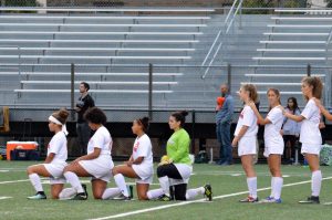 Four girls soccer players kneel during the national anthem Sept. 25. This act of protest has taken place at more than 50 high schools across the country according to NowThis News. 